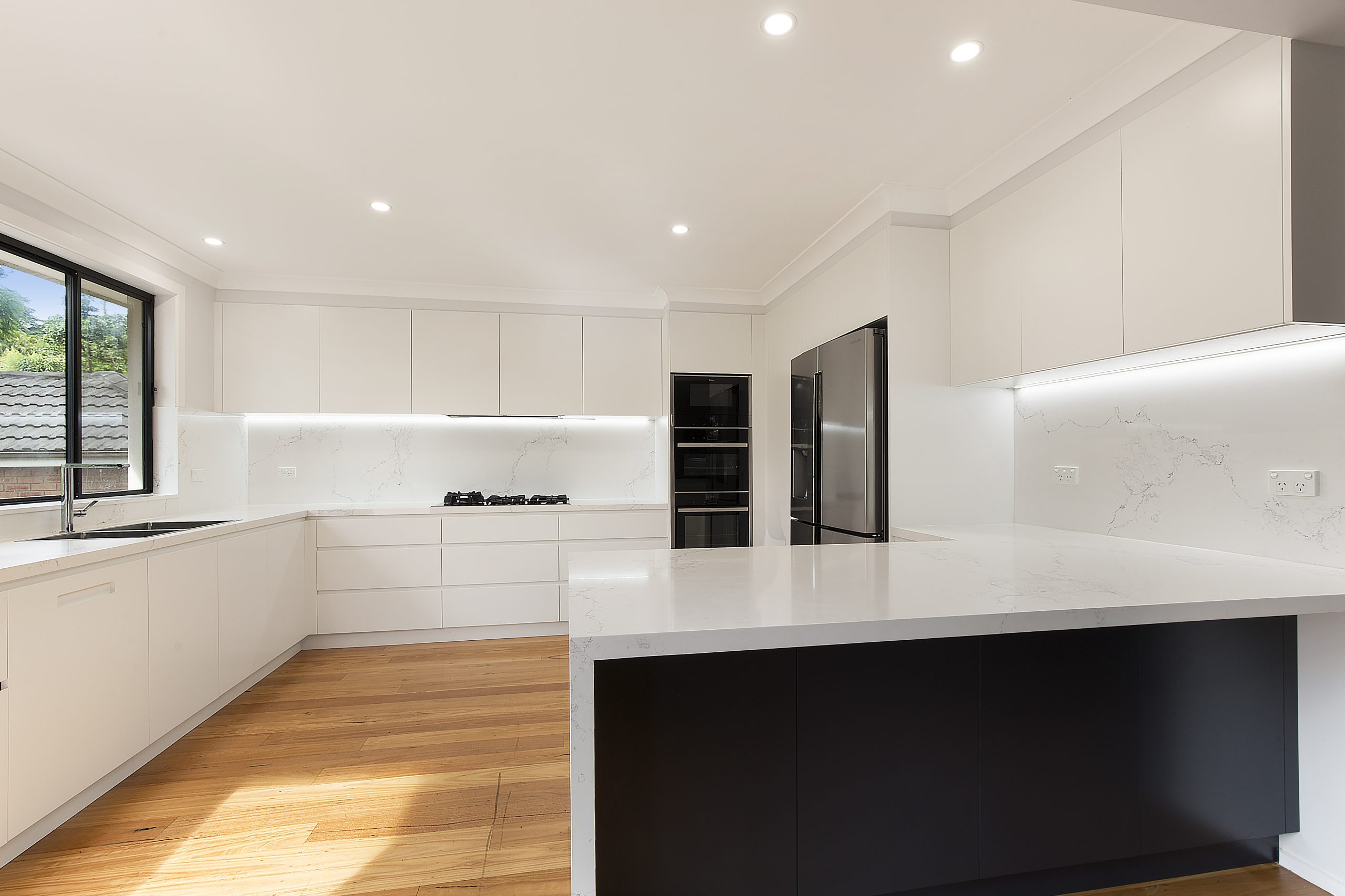 AFTER Forestville Renovation, Streamline polyurethane kitchen with integrated 45 degree handles