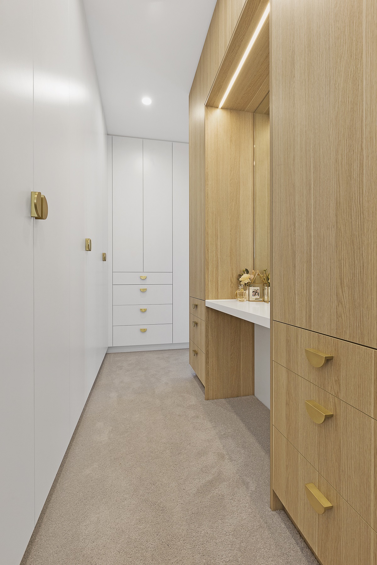 Walk-in wardrobe in a Satin Polyurethane and Timber Laminate combination with a built in vanity unit and mirror - Chipping Norton, Sydney