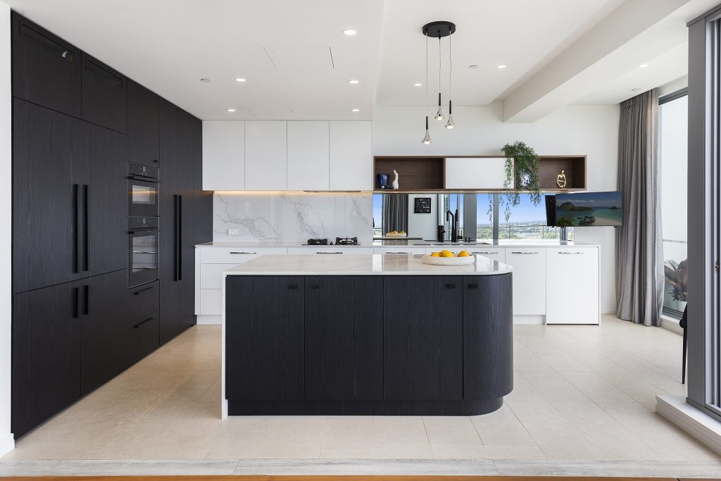 AFTER Milsons Point Renovation - Veneer Kitchen featuring a curved island bench with stone tops and splashback in Calcutta Plato