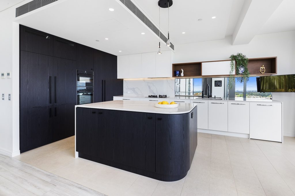 AFTER Milsons Point Renovation - Veneer Kitchen featuring a curved island bench with stone tops and splashback in Calcutta Plato
